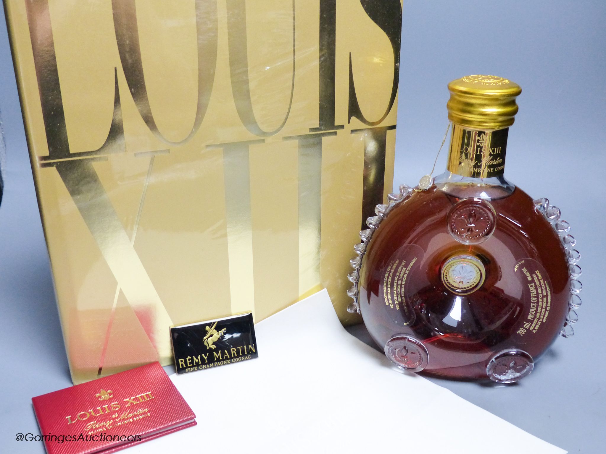 A sealed bottle of Louis XIII Remy Martin Grand Champagne Cognac, Carafe No.DJ9508, with original cloth and a sealed copy of Louis XIII Cognac The Thesaurus